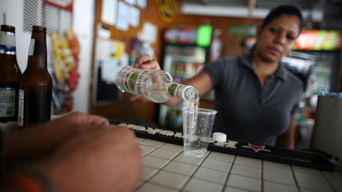 In this Friday, Sept. 7, 2012, file photo, a bartender fills a glass with rum at a bar in San Juan, Puerto Rico Small producers in countries such as Antigua, Guyana and Jamaica complain they are being punched by unfair trade and marketing advantages for global beverage corporations operating in U.S. territories, and say U.S. rum subsidies threaten to drive some beloved top-shelf Caribbean labels out of business, or force them to sell out.