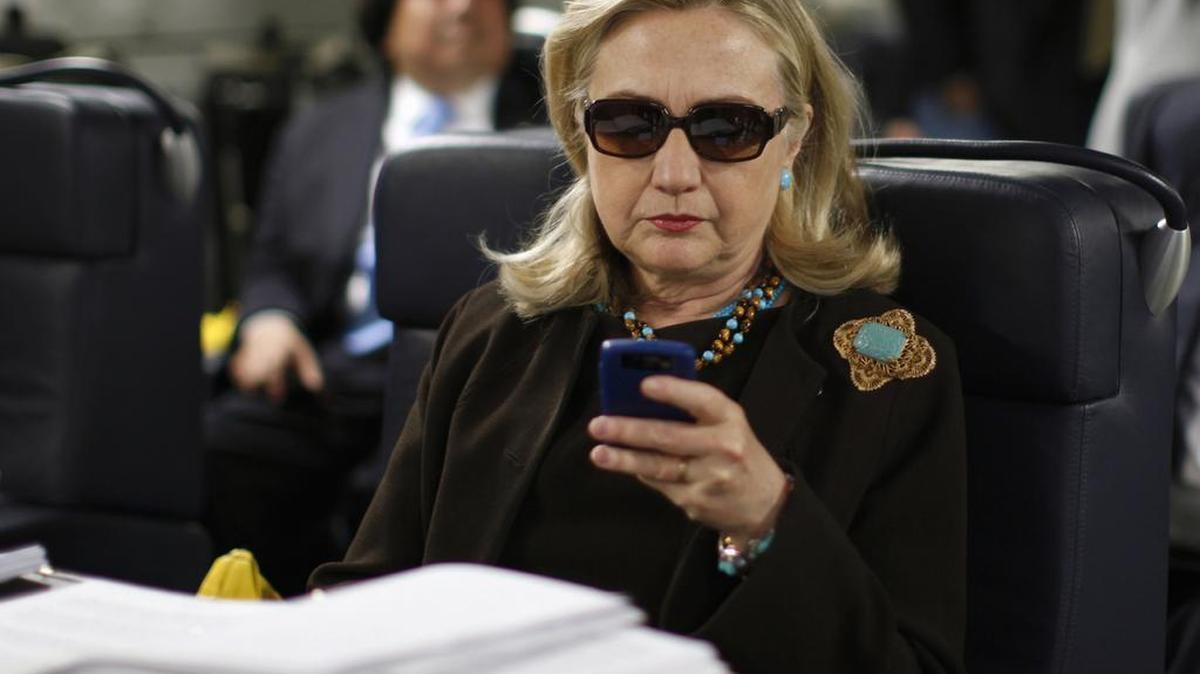 In this Oct. 18, 2011, file photo, then-Secretary of State Hillary Rodham Clinton checks her Blackberry from a desk inside a C-17 military plane upon her departure from Malta, in the Mediterranean Sea, bound for Tripoli, Libya. Newly released emails show a 2009 request to issue a secure government smartphone to then-Secretary of State Hillary Clinton was denied by the National Security Agency.