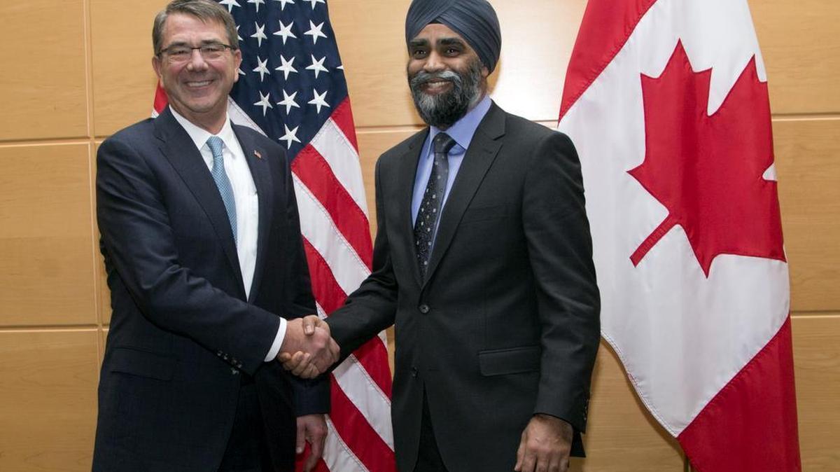 U.S. Secretary of Defense Ash Carter, left, shakes hands with Canadian Defense Minister Harjit Singh Sajjan.