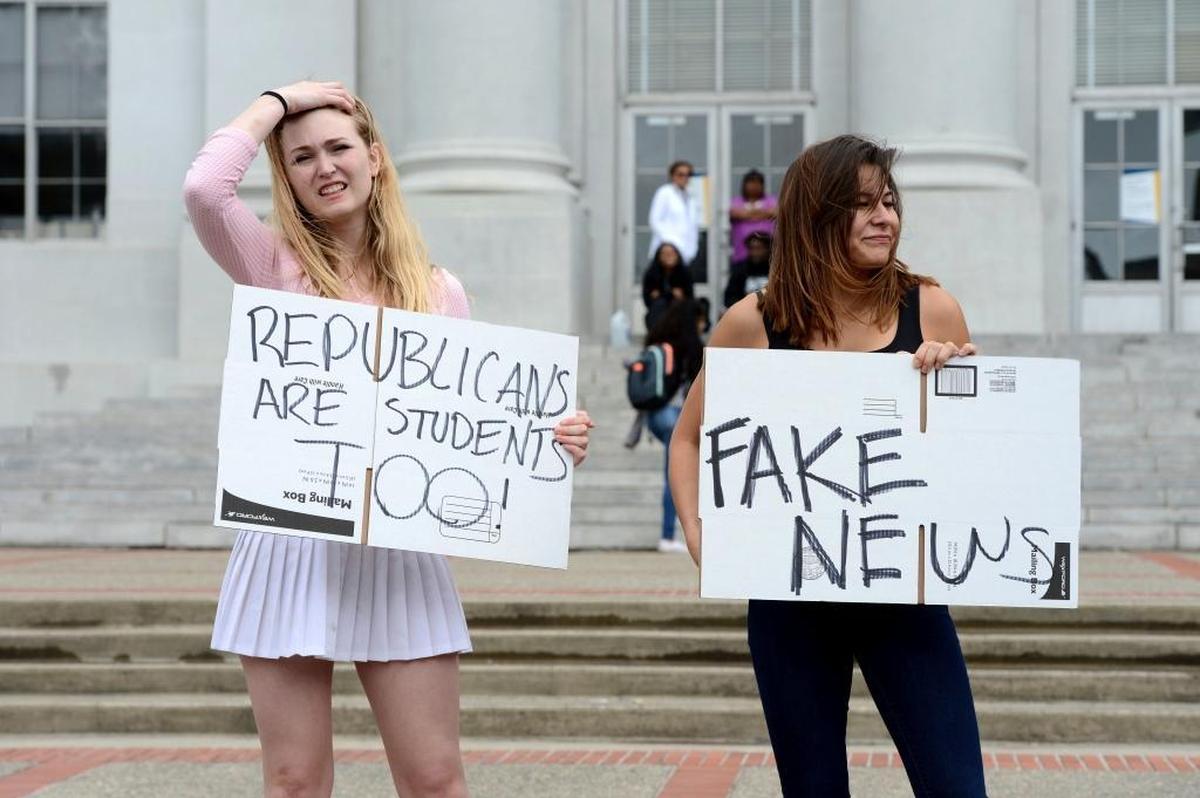 Ashton Whitty, left, 21, and Hailey Carlson, right, 24, University of California, Berkeley students, make their feelings known during a press conference held by the Berkeley College Republicans on the Cal campus in Berkeley, Calif., on April 26, 2017. The event was held to discuss the cancellation of speaker Ann Coulter's appearance on campus.