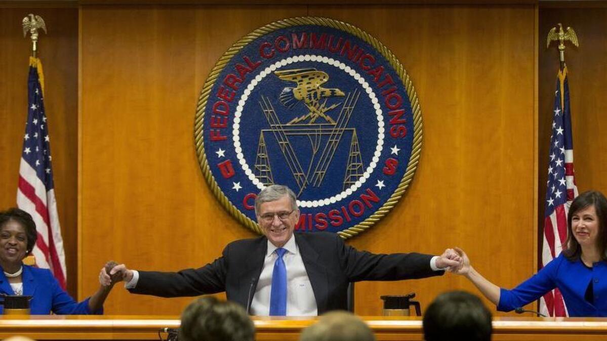 Federal Communication Commission Chairman Tom Wheeler, center, joins hands with FCC Commissioners Mignon Clyburn, left, and Jessica Rosenworcel before the start of their open hearing and vote on net neutrality, in Washington, Feb. 26, 2015.