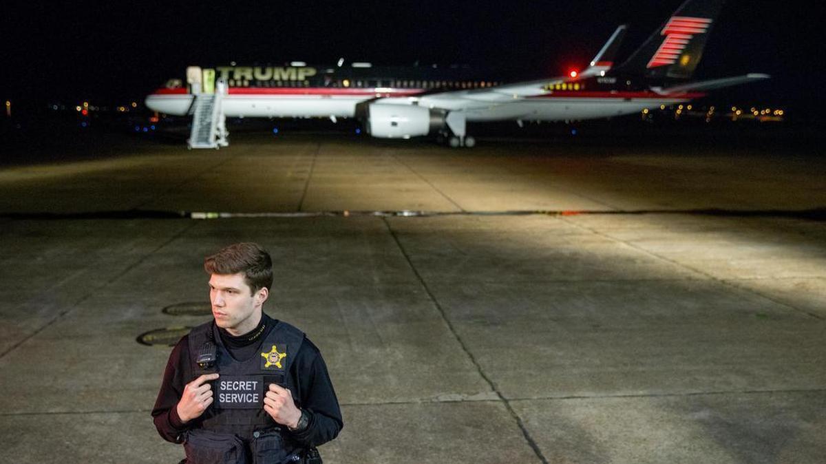 A member of the uniformed Secret Service stands in front of Republican presidential candidate Donald Trump’s plane as he prepares to depart after speaking at a rally at Millington Regional Airport in Millington, Tenn., on Saturday, Feb. 27, 2016.
