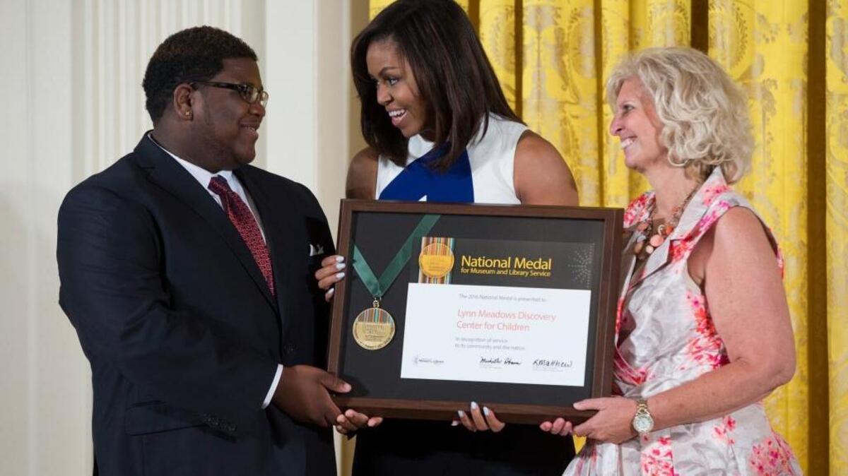 First lady Michelle Obama, center, presents a 2016 National Medal for Museum and Library Service award to Brandon Spann, left, and Cindy DeFrances of the Lynn Meadows Discovery Center for Children, of Gulfport, Miss., during a ceremony in the East Room of the White House, Wednesday, June 1, 2016, in Washington. Ten institutions from across the country received the highest award given to museums and libraries for service to the community.