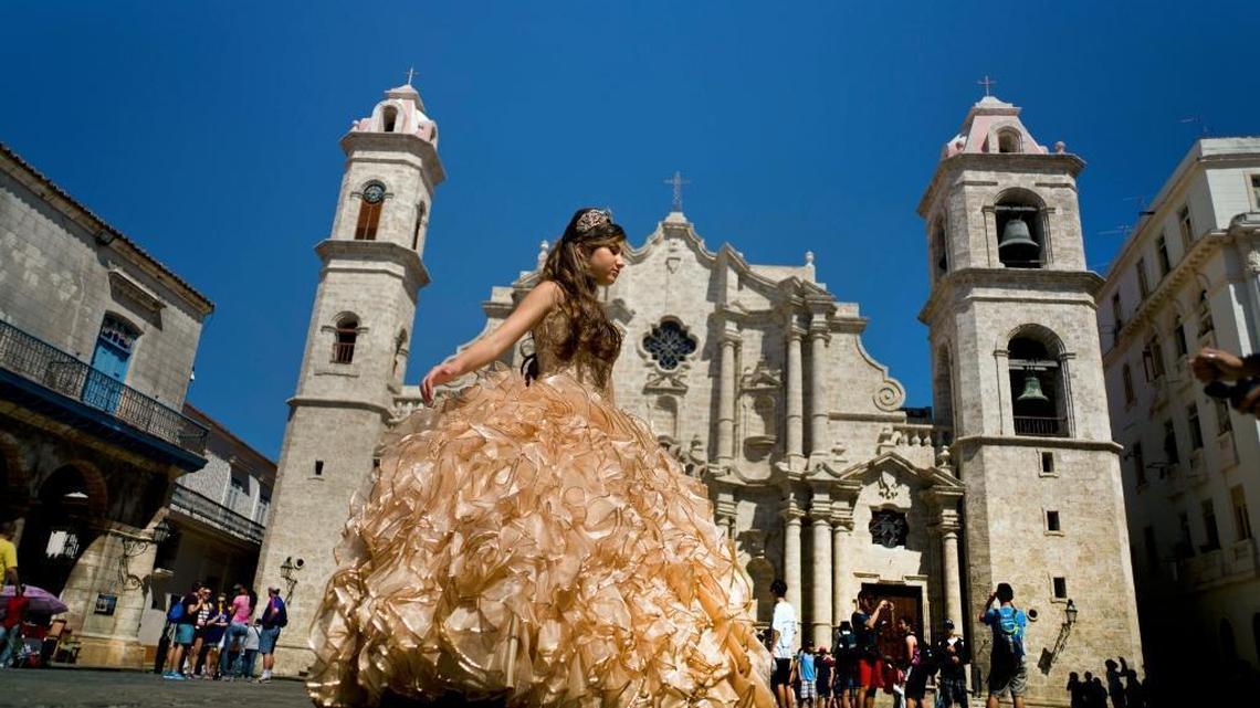 A "quinceanera" poses during her photo session in front of the cathedral as tourists line up to enter the building in Havana on March 14, 2016. Lawmakers want to block scheduled commercial airline service to Cuba after more than 10 American cities won tentative government approval advancing President Barack Obama's effort to normalize relations with Cuba.