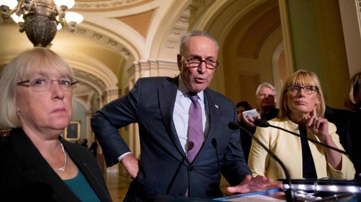 Senate Minority Leader Sen. Chuck Schumer of N.Y., accompanied by Sen. Patty Murray, D-Wash., left, and Sen. Maggie Hassan, D-N.H., right, speaks to reporters.