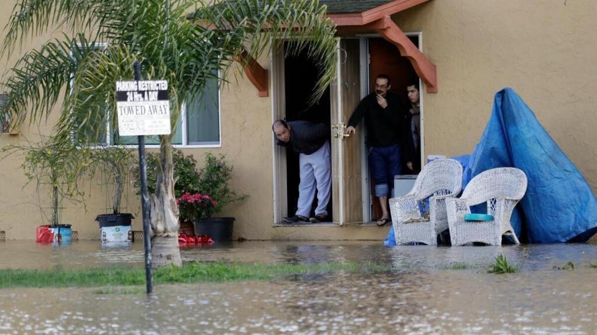 People look out from the front door of a flooded apartment complex in San Jose, Calif. Rains have saturated once-drought-stricken California but have created chaos for residents. The latest downpours swelled waterways to flood levels and left about half the state under flood, wind and snow advisories.