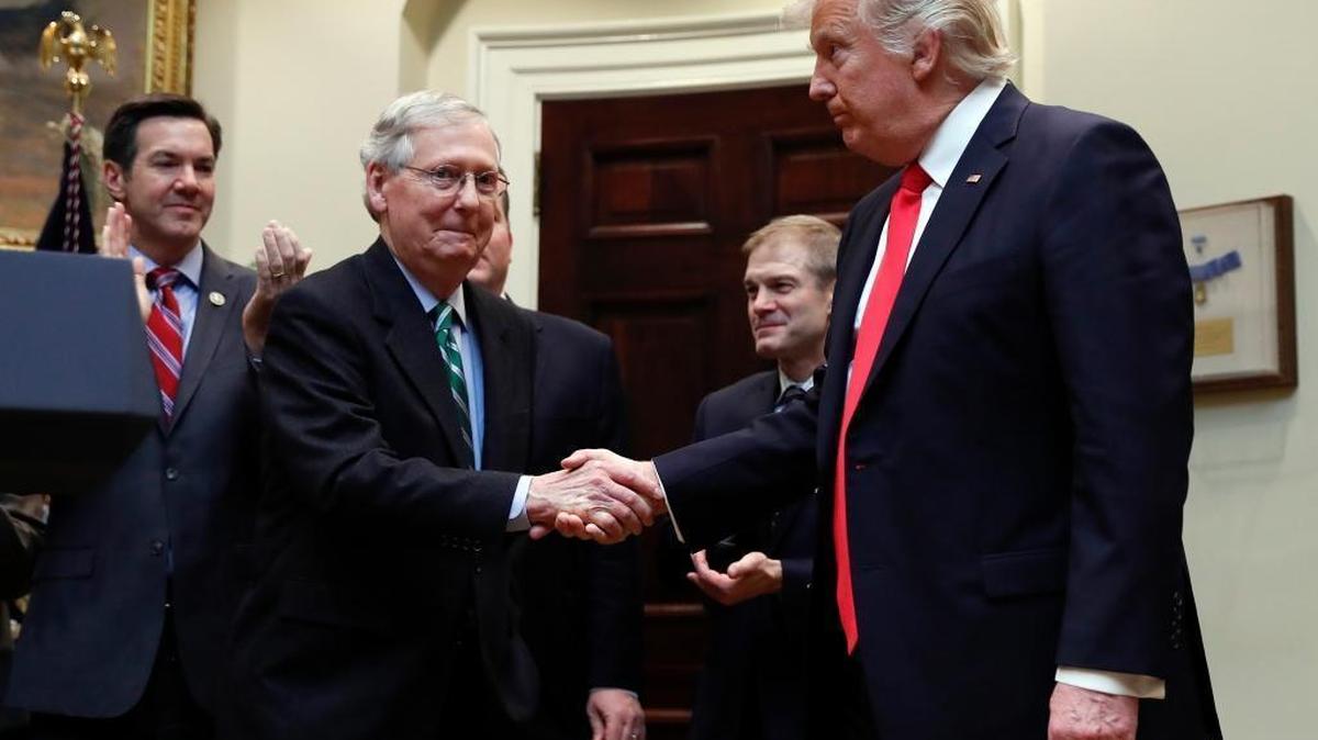 President Donald Trump shakes hands with Senate Majority Leader Mitch McConnell, R-Ky., during a ceremony where he will sign H.J. Res. 38 in the Roosevelt Room of the White House in Washington, Thursday, Feb. 16, 2017. Behind from left are Rep. Evan Jenkins, R-W.Va., and Rep. Jim Jordan, R-Ohio.