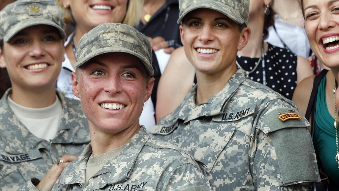U.S. Army First Lt. Shaye Haver, center, and Capt. Kristen Griest, right, pose for photos with other female West Point alumni after an Army Ranger school graduation ceremony, Friday, Aug. 21, 2015, at Fort Benning, Ga. Congress is still divided over the issue of having women register for the draft.
