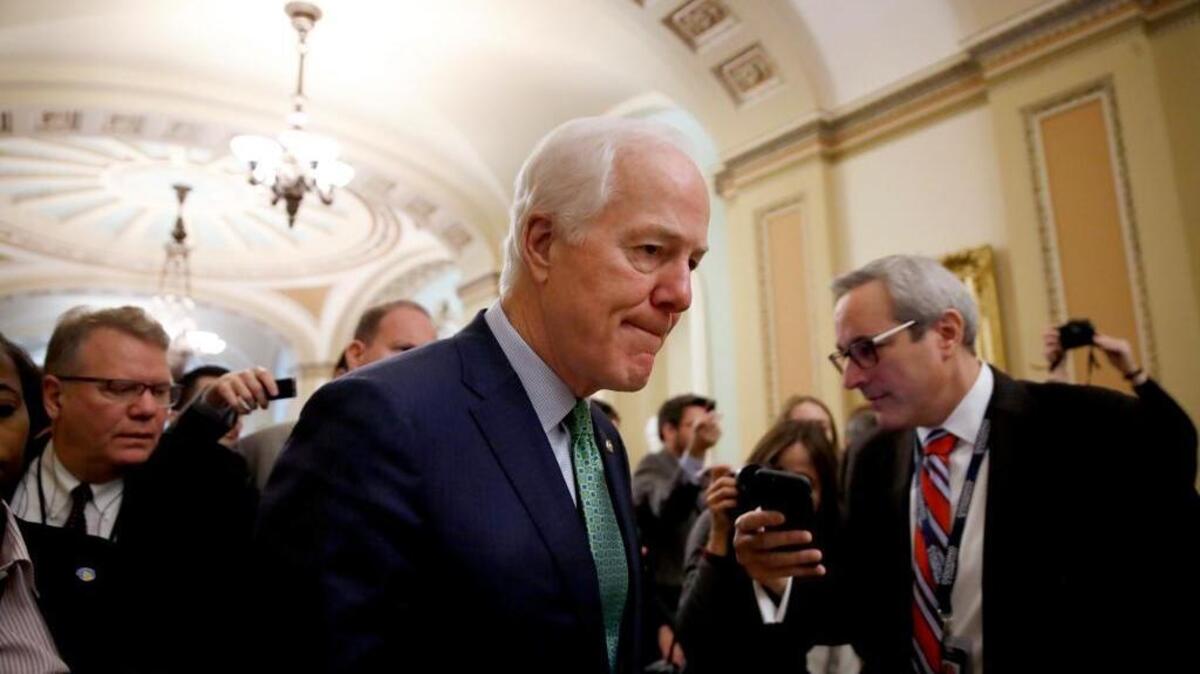Senate Majority Whip Sen. John Cornyn, R-Texas, center, will see his plan to toughen background checks for prospective gun buyers included in a new budget bill.