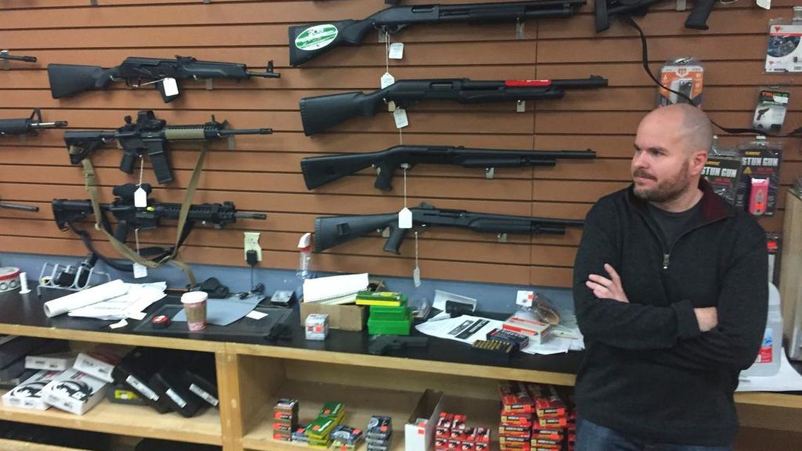 Firearms salesman Nathan Williams, 37, of Albuquerque, attends to customers at The Outdoorsman gun shop in Santa Fe, N.M.
