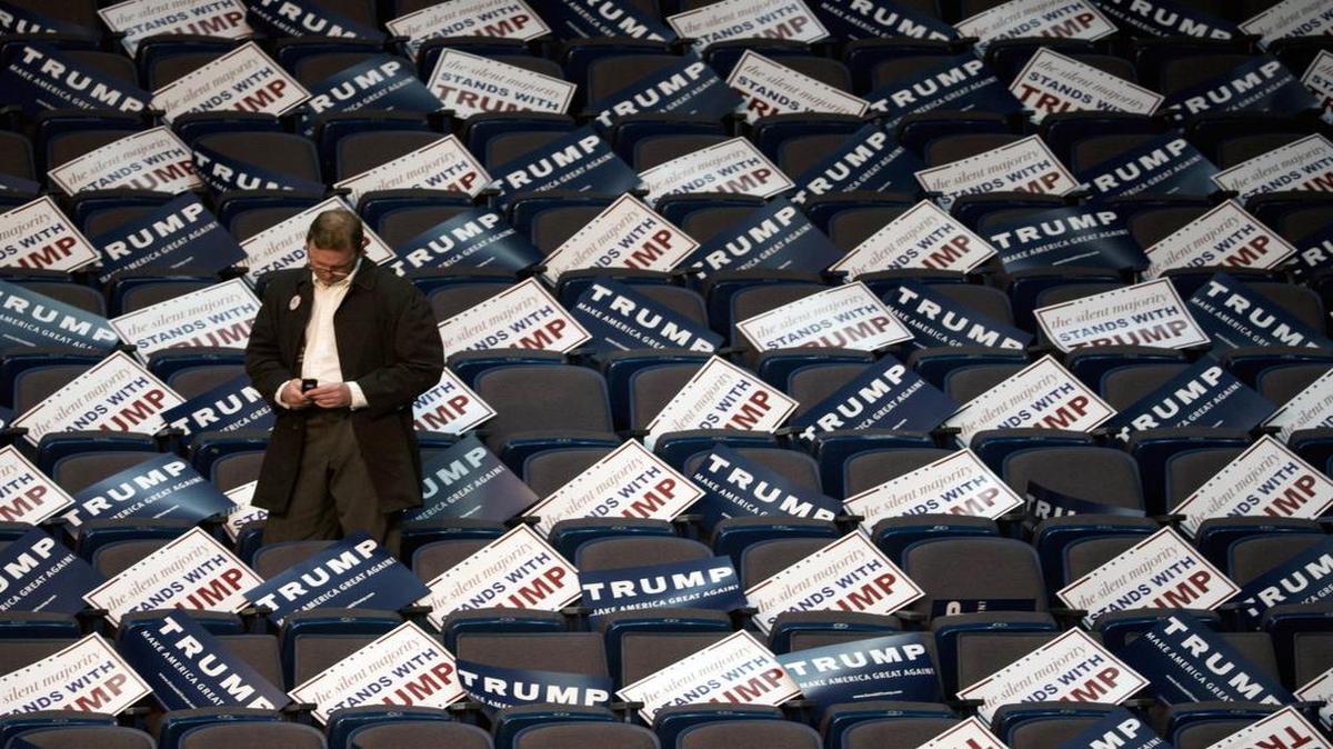 A man is surrounded by campaign signs before a rally for Republican presidential candidate Donald Trump at the Times Union Center on Monday, April 11, 2016, in Albany, N.Y.