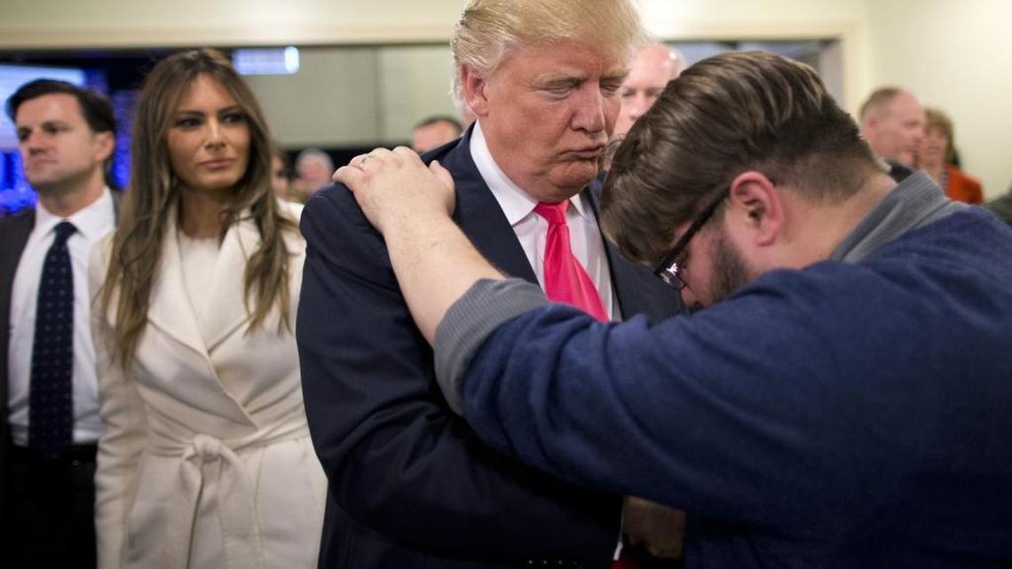 Pastor Joshua Nink, right, prays for Republican presidential candidate Donald Trump, as his wife, Melania, left, watches after a Sunday service at First Christian Church, in Council Bluffs, Iowa. Trump has vowed to “totally destroy” a 1950s law preventing churches from endorsing or opposing political candidates.