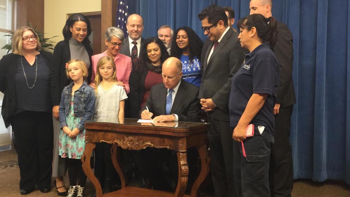 Gov. Jerry Brown signs Assembly Bill 908 in his office Monday, April 11, 2016. The bill expands the state’s family leave program. Assemblyman Jimmy Gomez, D-Los Angeles, the bill’s author stands at the governor’s left.