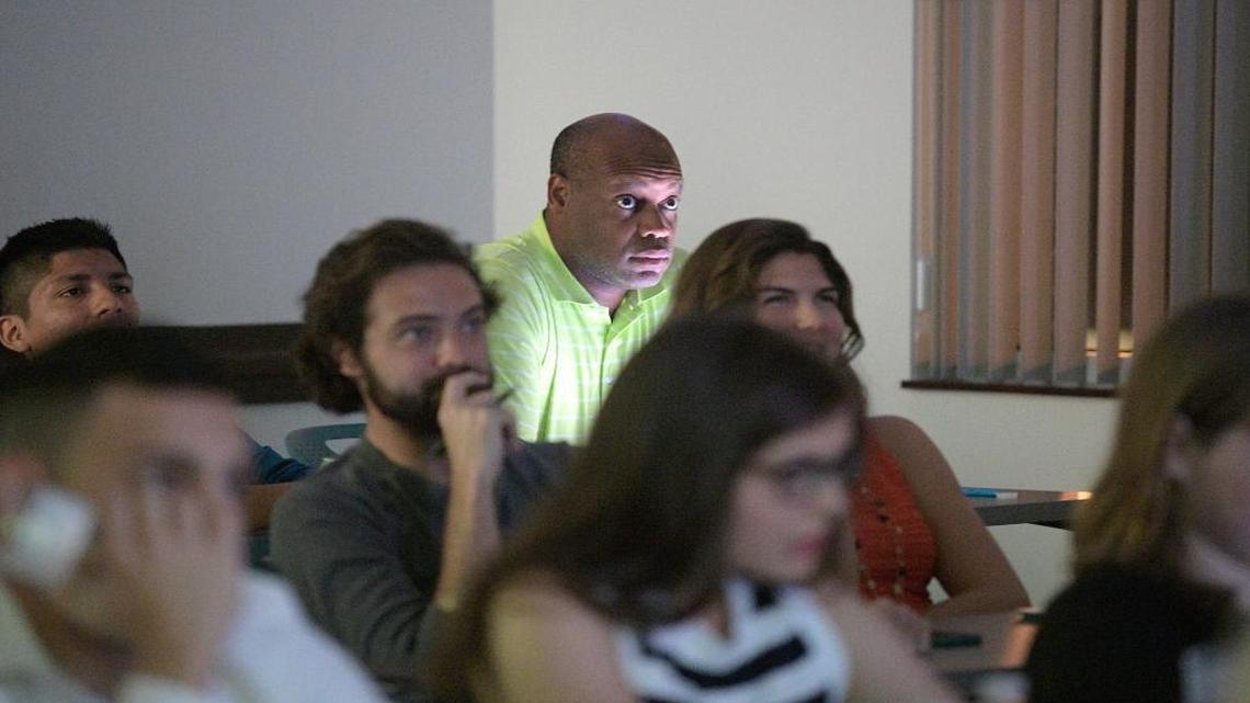 Derek Bruce, center, watches as Democratic Presidential nominee Hillary Clinton talks about trade and open borders during a campaign debate focus group viewing of the third Presidential debate in Orlando, Fla., on Oct. 22, 2016.
