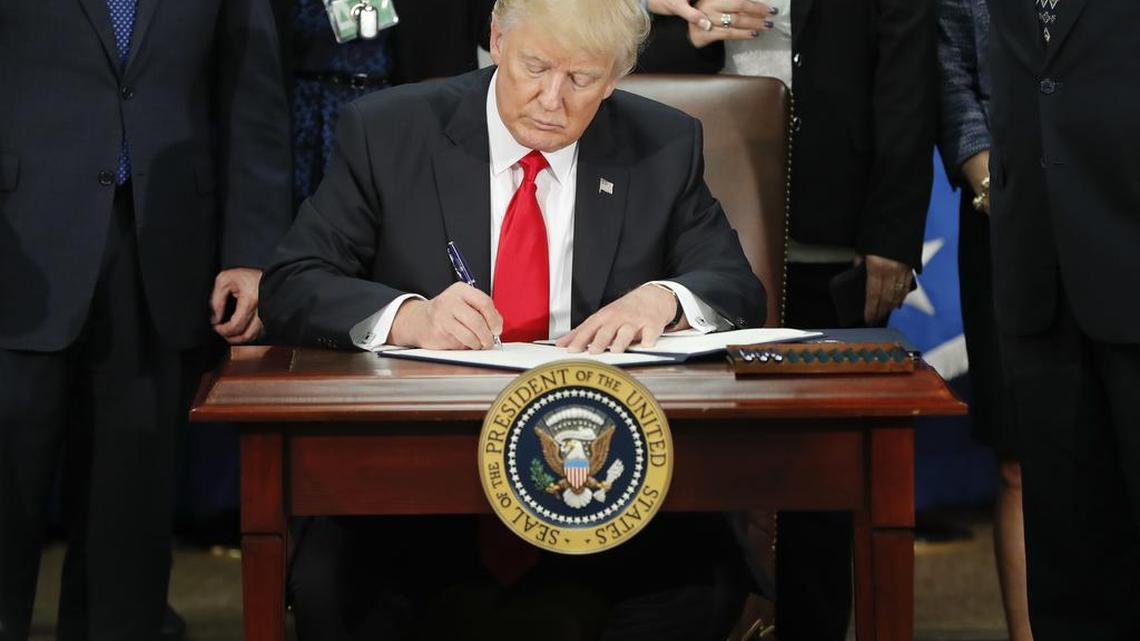 President Donald Trump signs an executive order for border security and immigration enforcement improvements, Wednesday, Jan. 25, 2017, at the Homeland Security Department in Washington.