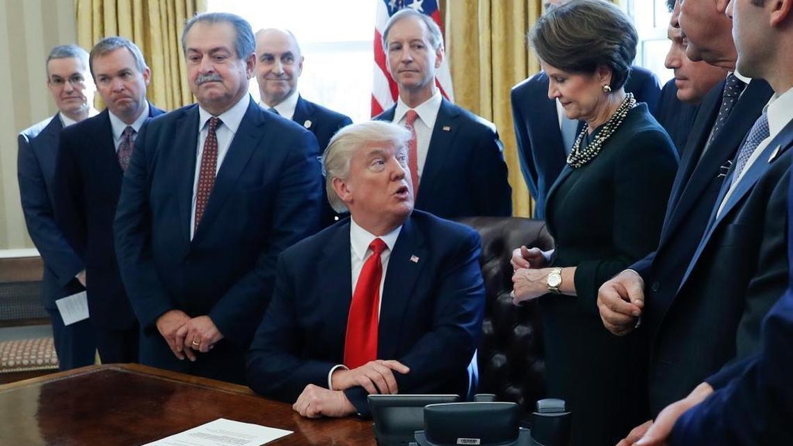 President Donald Trump looks over to Lockheed Martin Chairwoman, President and CEO Marillyn Hewson, right, before signing an executive order in the Oval Office of the White House in Washington, Feb. 24, 2017. At left is Dow Chemical President, Chairman and CEO Andrew Liveris.