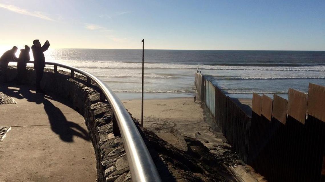 People look out where a border structure separates San Diego, right, from Tijuana, Mexico, left, Jan. 25, 2017. President Donald Trump has moved aggressively to tighten immigration controls.