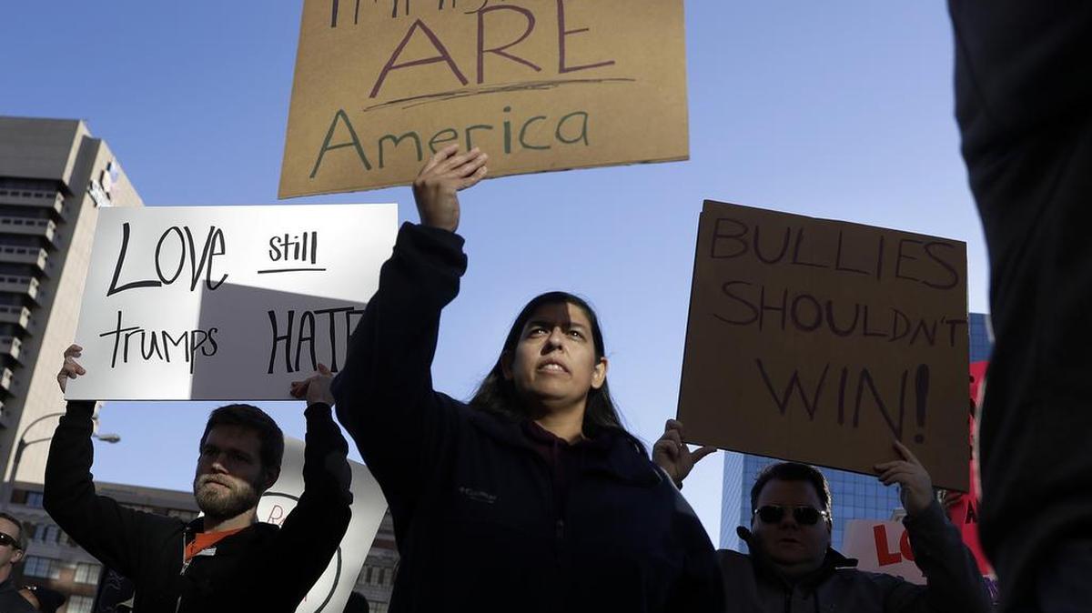 Protesters hold signs as they march in opposition to the election of President-elect Donald Trump on Sunday, Nov. 13, 2016, in St. Louis.