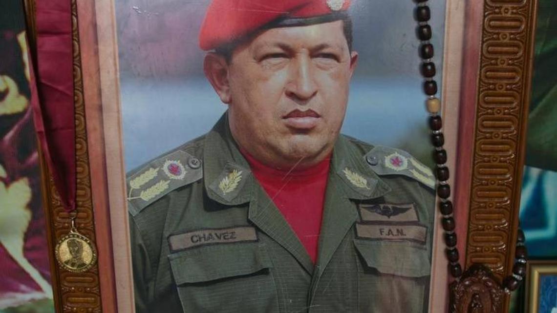 A photo of Venezuela's late president Hugo Chavez is seen inside a small chapel with two cups of coffee as an offering at the 4F military museum to commemorate what would have been the leader's 62th birthday in Caracas, Venezuela.