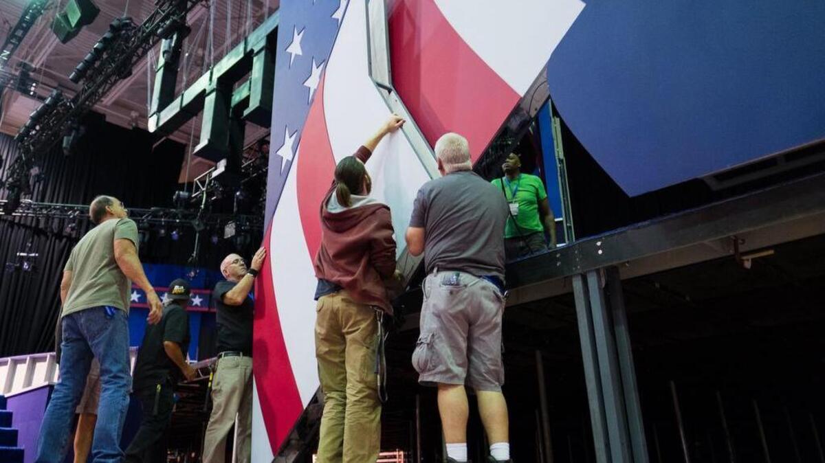 Construction crews hang part of the set as preparations continue for the Monday, Sept. 26, 2016, presidential debate between Democrat Hillary Clinton and Republican Donald Trump, Saturday, Sept. 24, 2016, at Hofstra University in Hempstead, N.Y.