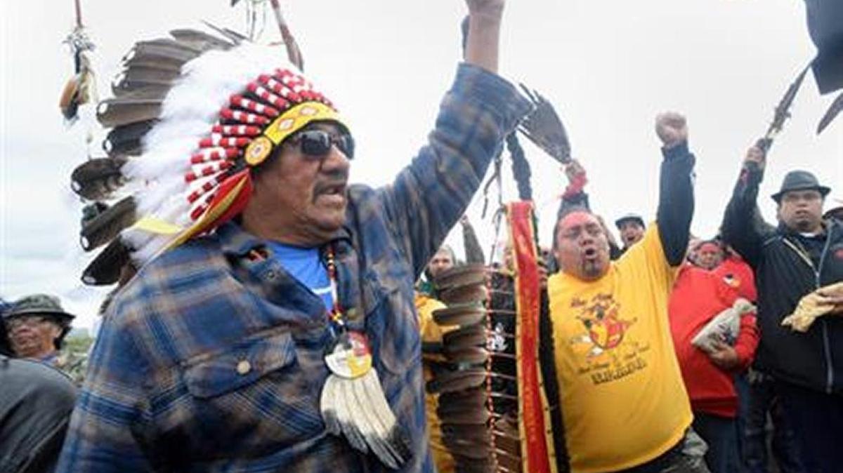 JR American Horse, left, raises his fist with others while leading a march to the Dakota Access Pipeline site in southern Morton County, North Dakota. Several hundred protesters marched about a mile up Hwy 1806 on Sept. 9, 2016, from the protest camp to the area of the pipeline site where some archaeological artifacts have been discovered.