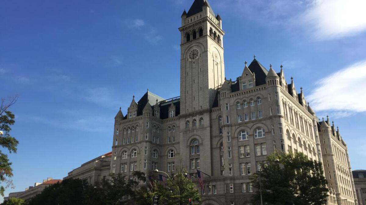 The Trump International Hotel in Washington, Wednesday, Oct. 26, 2016. The Trump name can be seen in gold under an arch beneath the flags. Donald Trump took time out from his presidential campaign to cut a ribbon at the hotel with his family Wednesday.