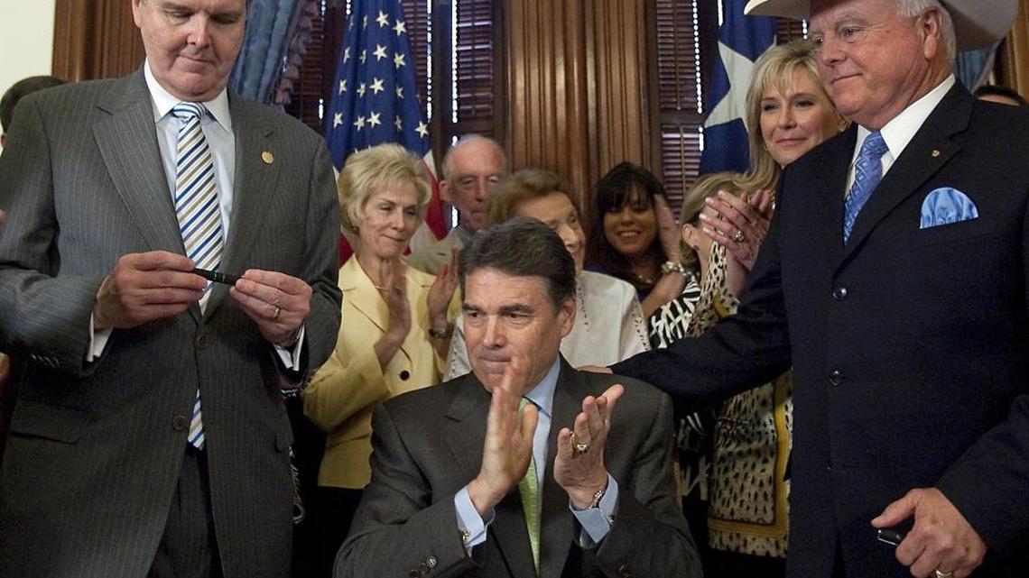 Texas Gov. Rick Perry, center, begins to applaud after signing the sonogram bill as sponsors Sen. Dan Patrick, R-Houston, left, and House Rep. Sid Miller, R-Stephenville, right, and pro life supporters look at the State Capitol in Austin, Texas in 2011. The sonogram bill requires that women considering an abortion an opportunity must first get a sonogram and wait 24 hours before having an abortion.