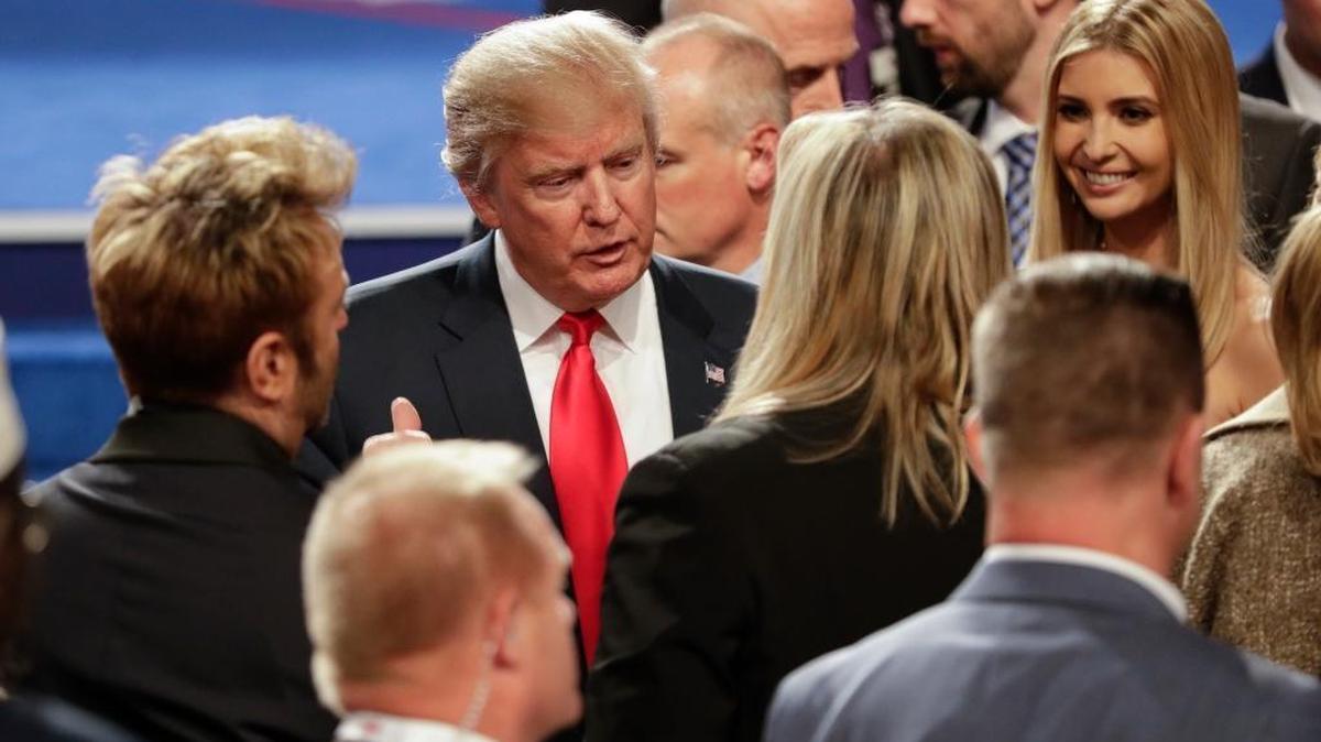 Republican presidential nominee Donald Trump talks with members of the audience Wednesday, Oct. 19, 2016, after the third presidential debate, in which he claimed credit for NATO defense spending increases by U.S. allies.