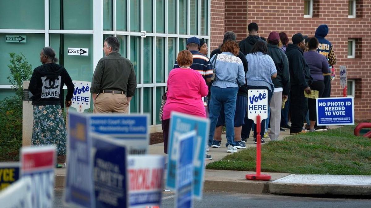 Voters stand in line early Thursday morning, Oct. 20, 2016, at the Beatties Ford Road Regional Library in Charlotte, N.C. Thursday is the first day of early in-person voting in North Carolina.