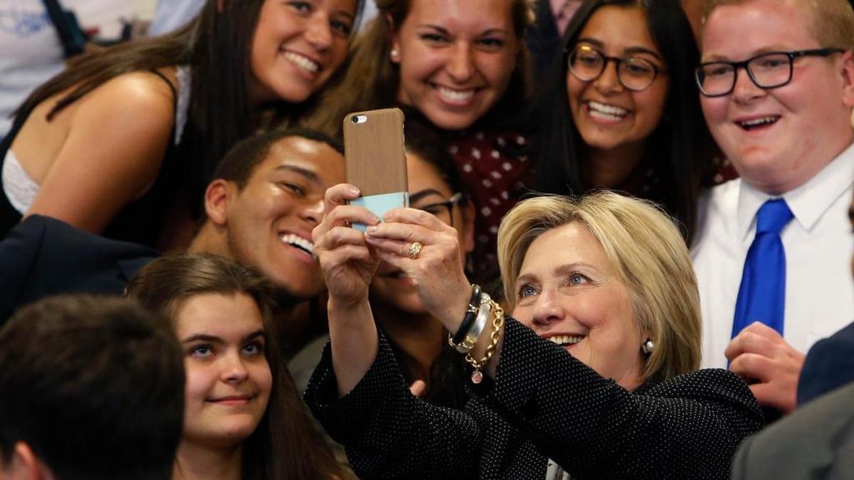In this June 21, 2016, file photo, Democratic presidential candidate Hillary Clinton takes a photo with supporters after speaking at Fort Hayes Vocational School in Columbus, Ohio. A new poll finds that young voters are starting to come through for Clinton, particularly whites ages 18 to 30.