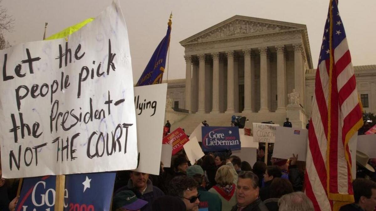 Protesters hold signs and flags in front of the U.S. Supreme Court after the 2000 election resulted in a recount as a result of Al Gore winning the popular vote, but George W. Bush winning more electoral votes. The court decided the outcome in favor of Bush. Experts say the likelihood of a split vote this year between Hillary Clinton and Donald Trump is unlikely, but the polls are close and it’s not out of the question.