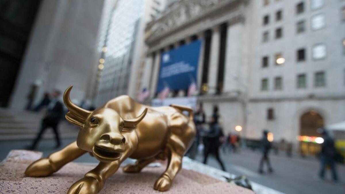 FILE - In this Tuesday, Oct. 25, 2016, photo, a miniature reproduction of Arturo Di Modica's "Charging Bull" sculpture sits on display at a street vendor's table outside the New York Stock Exchange, in lower Manhattan. Stocks are opening slightly higher on Wall Street, giving the market a chance to break its longest losing streak in five years, Thursday, Nov 3.