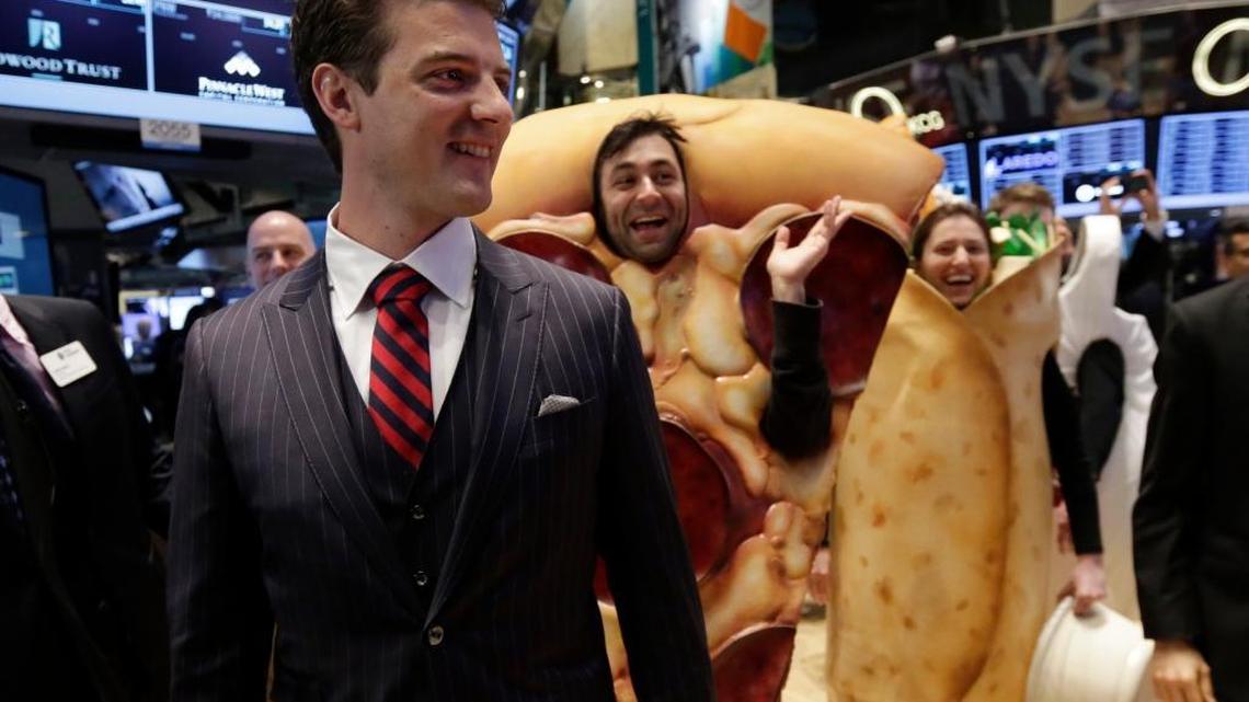 GrubHub Inc. CEO Matthew Maloney, trailed by costume characters, walks the New York Stock Exchange trading floor before his company's IPO begins trading, Friday, April 4, 2014. Investors sent shares of the online food ordering service up 51 percent to $39.20 in early trading in its stock market debut Friday.