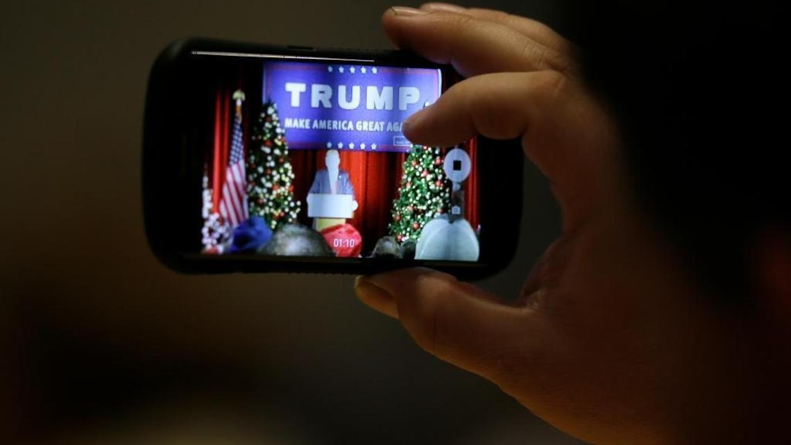 An audience member snaps a cell phone photo as Republican presidential candidate Donald Trump speaks during a campaign rally at the Veterans Memorial Building, Saturday, Dec. 19, 2015, in Cedar Rapids, Iowa.