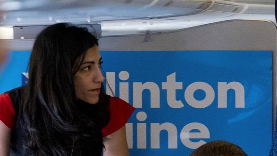 Democratic presidential candidate Hillary Clinton speaks with senior aide Huma Abedin aboard her campaign plane Friday, Oct. 28, 2016, before traveling to Iowa for rallies.