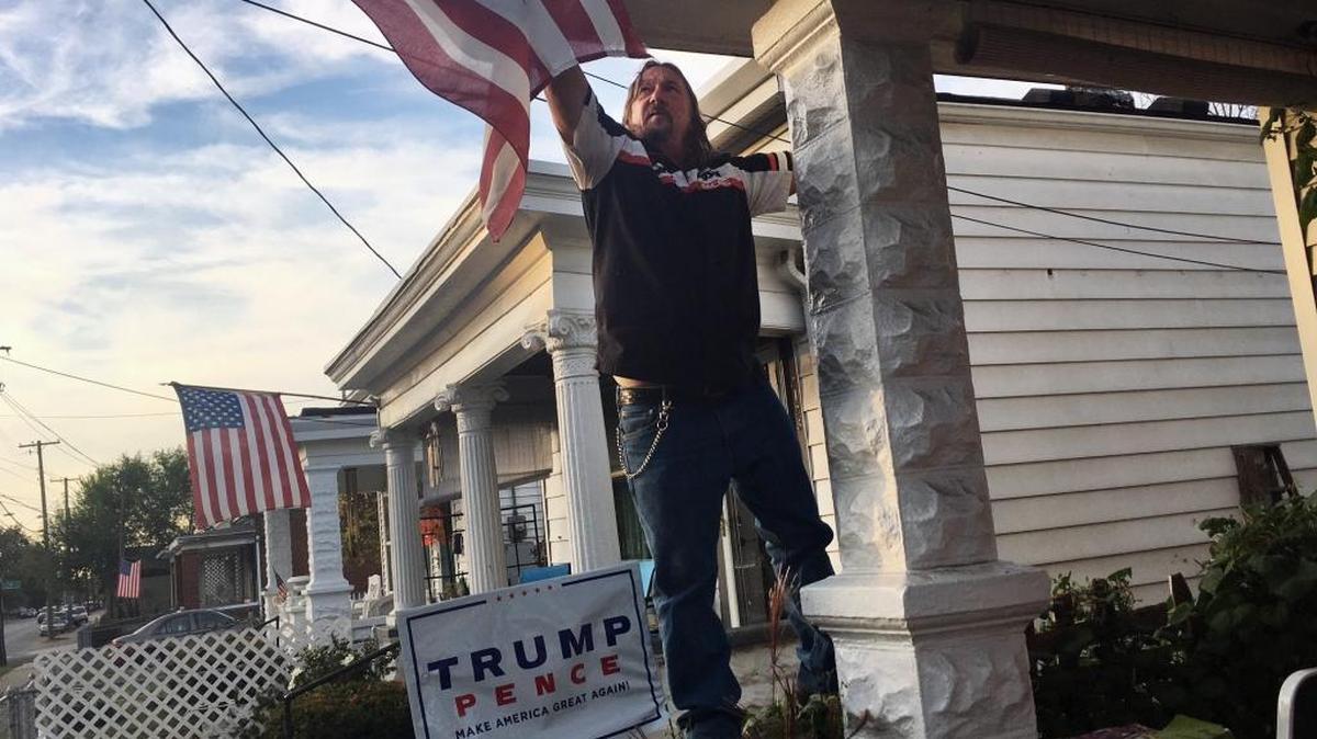 Terry Wright, a 59-year-old retired union painter, adjusts the U.S. flag on his porch in Portland, a white, working class neighborhood in Louisville, Ky., on Tuesday, Nov. 1, 2016. Wright, a registered Democrat backing Republican presidential candidate Donald Trump, says he has given up on his old party.