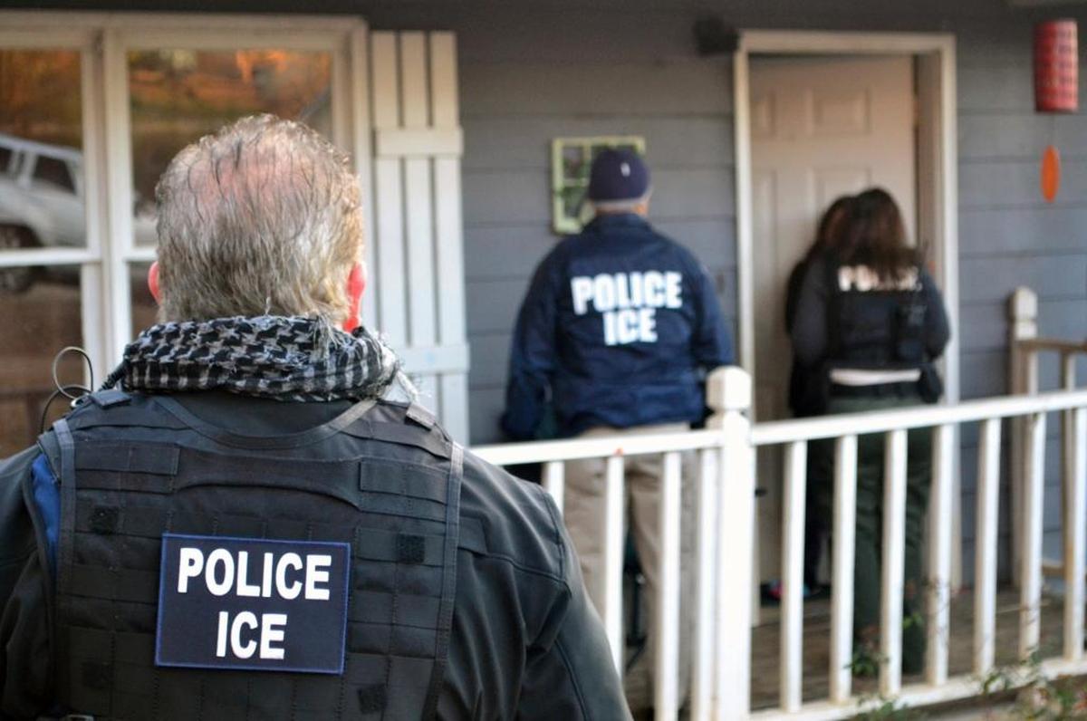 Immigration enforcement agents stand outside a home in Atlanta during a targeted enforcement operation aimed at immigration fugitives, re-entrants and at-large criminals living in the country illegally. ICE provided this photo.