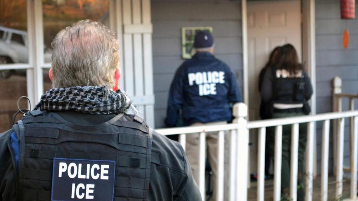 Immigration enforcement agents stand outside a home in Atlanta during a targeted enforcement operation aimed at immigration fugitives, re-entrants and at-large criminals living in the country illegally. ICE provided this photo.