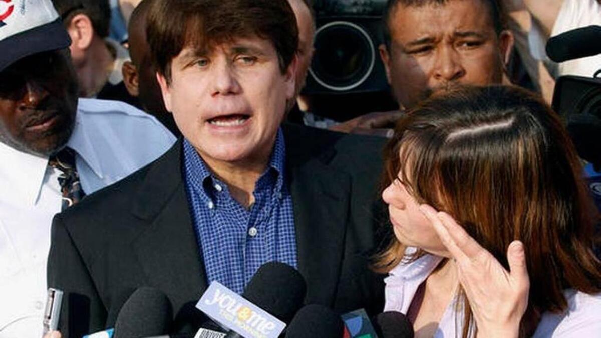 Former Illinois Gov. Rod Blagojevich speaks to the media as his wife, Patti, wipes away tears a day before he was to report to a prison after his conviction on corruption charges. Blagojevich is in the fourth year of a 14-year prison term after being convicted of trying to sell Obama’s Illinois seat in the U.S. Senate when Obama became president.