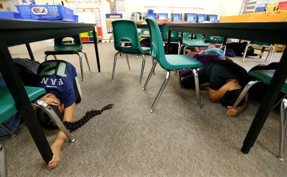 Children in Anita Blaisdell’s first-grade class at Midland Elementary School in Tacoma, Wash., take shelter under tables during an earthquake drill, on Oct. 20, 2016. Schools, businesses, and community organizations conducted similar exercises across the state as part of the annual Great Washington ShakeOut earthquake and tsunami readiness program.