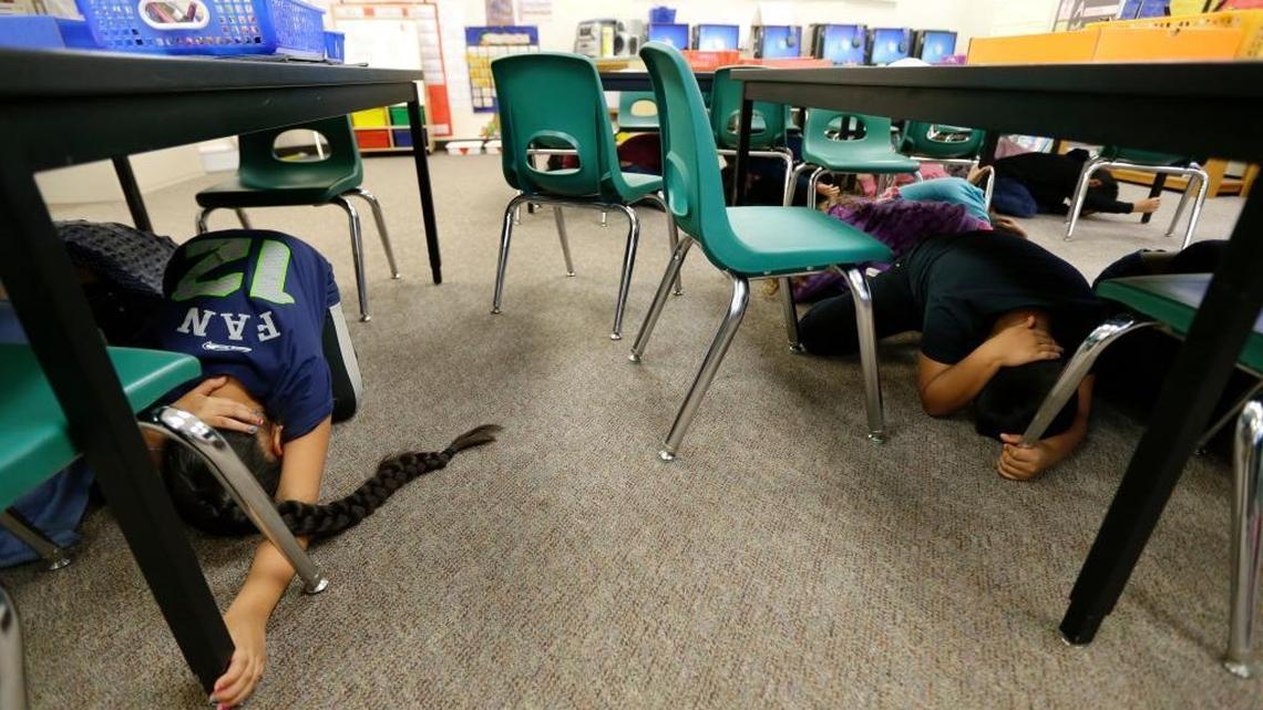 Children in Anita Blaisdell's first-grade class at Midland Elementary School in Tacoma, Wash., take shelter under tables during an earthquake drill, on Oct. 20, 2016. Schools, businesses, and community organizations conducted similar exercises across the state as part of the annual Great Washington ShakeOut earthquake and tsunami readiness program.