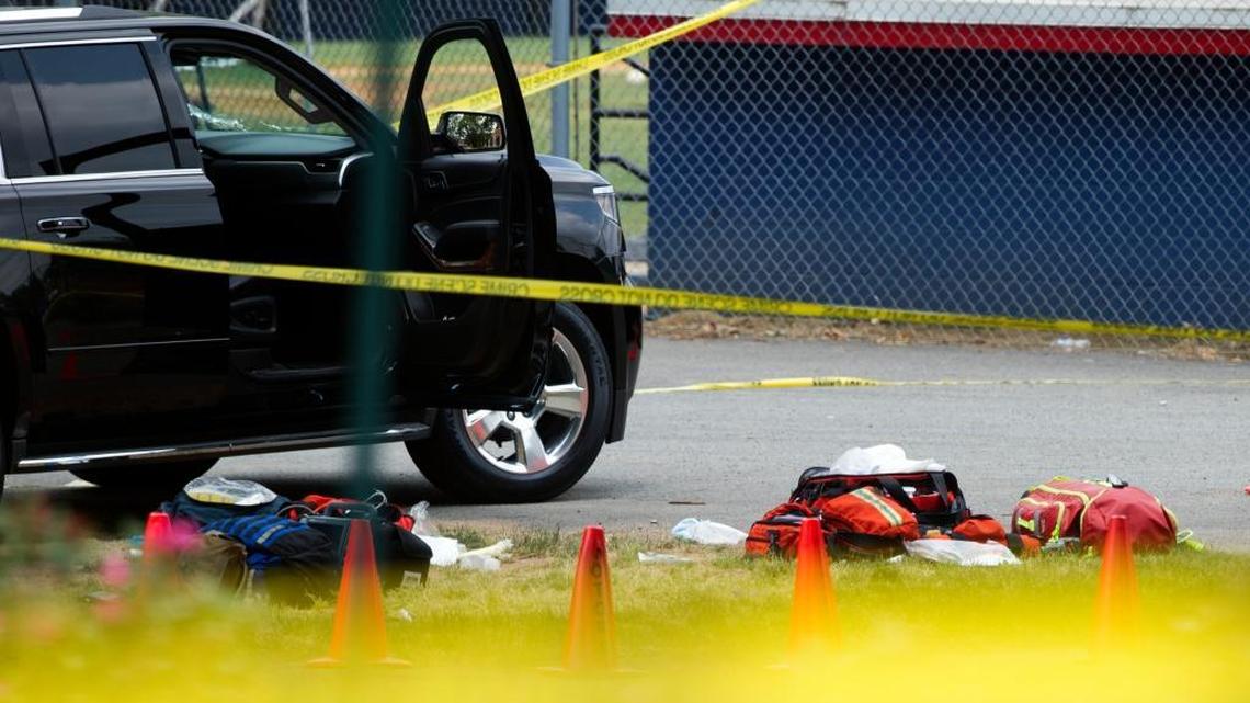 Bags lay on the ground near an automobile with a bullet hole in its windshield in the parking lot of the ball field in Alexandria, Va., Wednesday, June 14, 2017, which was the scene of a multiple shooting involving House Majority Whip Steve Scalise of La., and others, were shot during a congressional baseball practice.