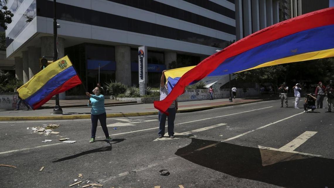 Anti-government demonstrators wave Venezuelan national flags during a protest against Venezuela's President Nicolas Maduro in Caracas, Venezuela, Tuesday, Aug. 8, 2017.