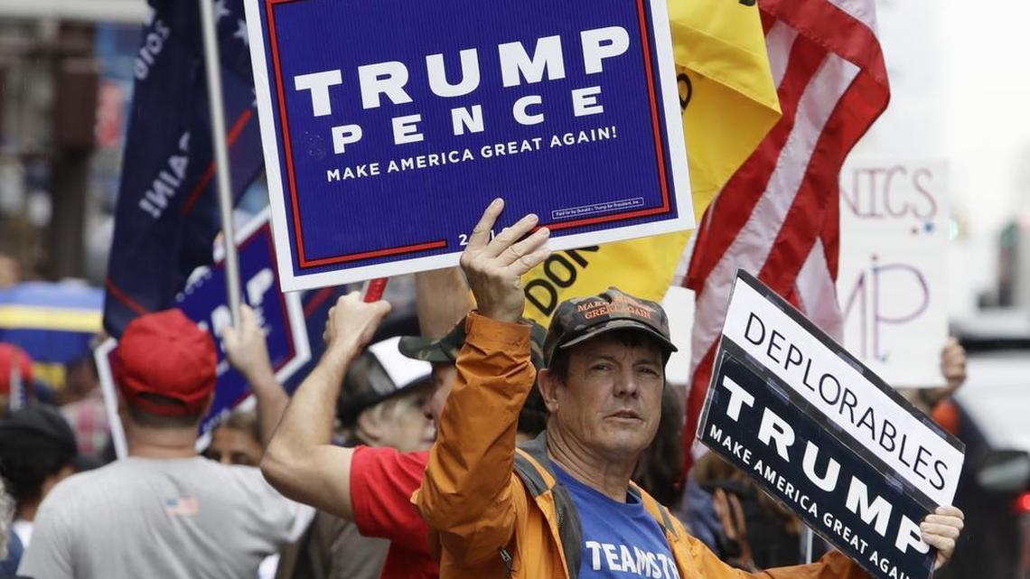 Supporters of Republican presidential nominee Donald Trump gather at Trump Tower Saturday, Oct. 8, 2016, in New York. Dozens of Republicans have called for the candidate to exit the race.