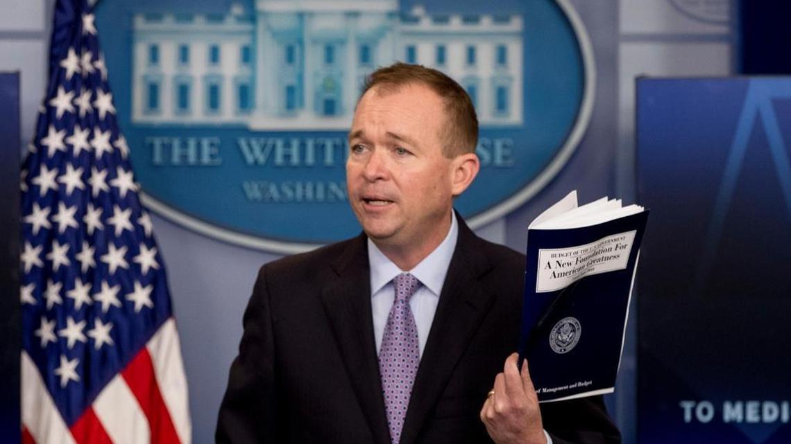 Budget Director Mick Mulvaney holds up a copy of President Donald Trump’s proposed fiscal 2018 federal budget as he speaks to members of the media in the Press Briefing Room of the White House in Washington, Tuesday, May 23, 2017.