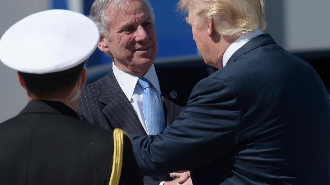President Donald Trump shakes hands with South Carolina Gov. Henry McMaster after arriving on Air Force One at Charleston International Airport in North Charleston, S.C.