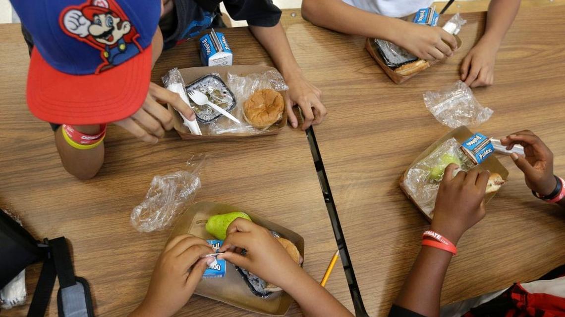 Students at the Maurice J. Tobin K-8 School in Boston's Roxbury neighborhood eat free lunches consisting of a sandwich with meat, a vegetable dish, a piece of fruit and milk, Sept. 4, 2013.