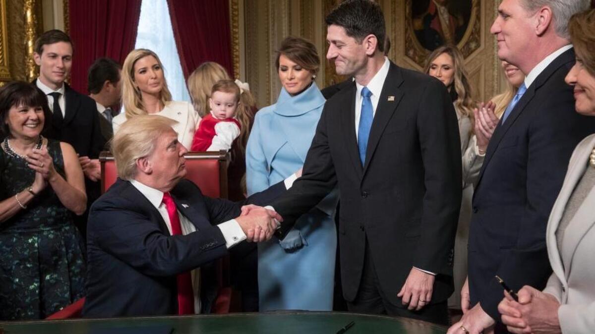President Donald Trump shakes House Speaker Paul Ryan’s hand as he is joined by GOP leaders and his family in formally signing his Cabinet nominations into law in the President's Room of the Senate at the Capitol on Friday, Jan. 20, 2017.