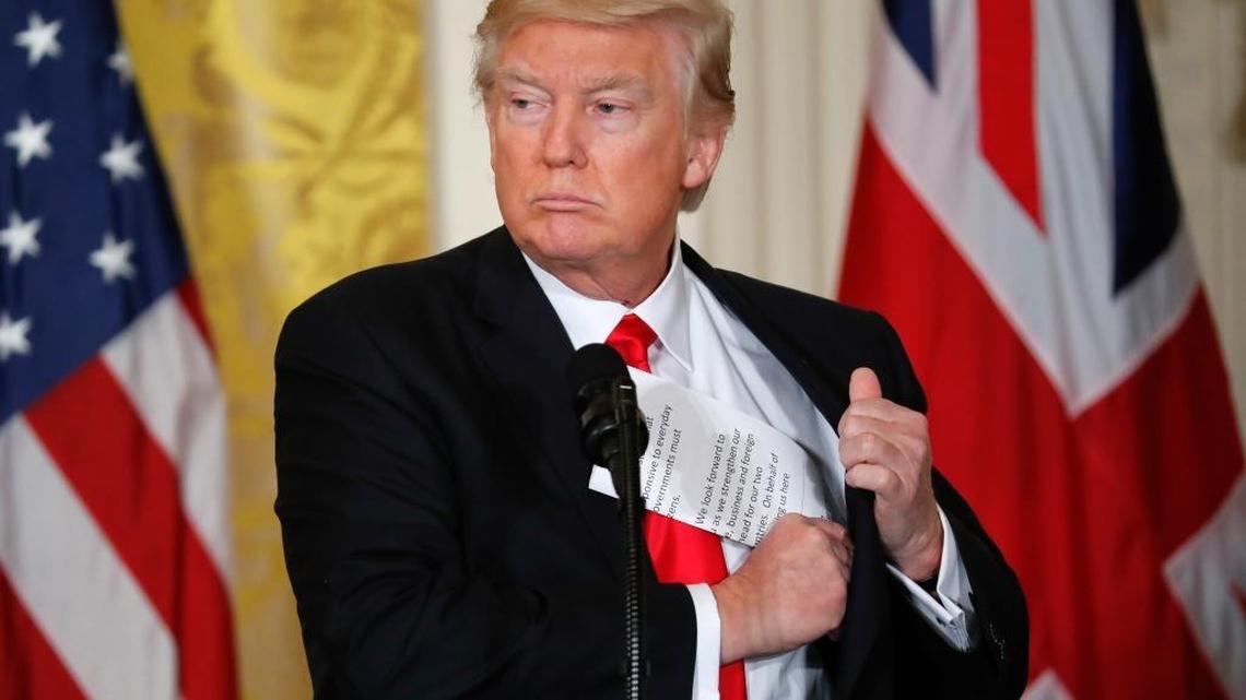 President Donald Trump tucks away his notes near the end of a joint news conference with British Prime Minister Theresa May in the East Room of the White House in Washington, Jan. 27, 2017.