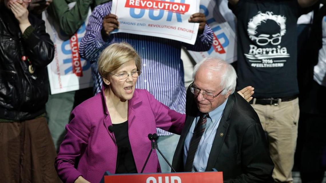 Sens. Elizabeth Warren, D-Mass., left, and Bernie Sanders, I-Vt., right, greet one another during a rally Friday, March 31, 2017, in Boston. The Republican group America Rising PAC is tracking both of them in preparation for the 2020 election.